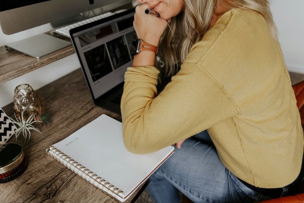 Young woman office worker holding her head and suffering stress working